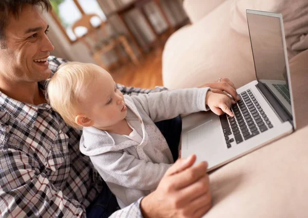 Mostrando a papa 'come si fa. Un giovane padre che mostra alla sua bambina come usare un computer portatile. — Foto Stock