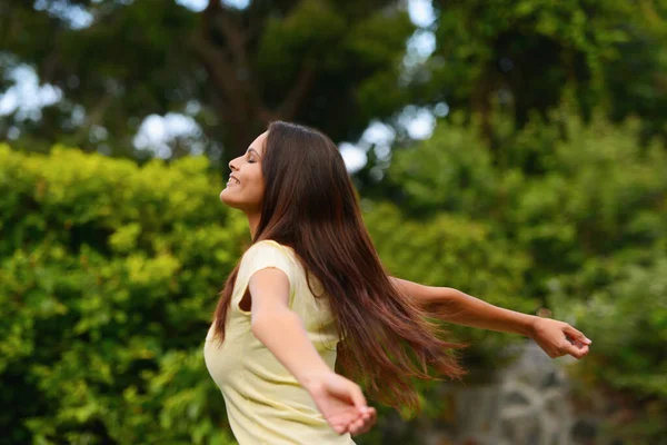 Completamente gratis. Girato di una donna godendo la vita all'aria aperta con le braccia alzate. — Foto Stock