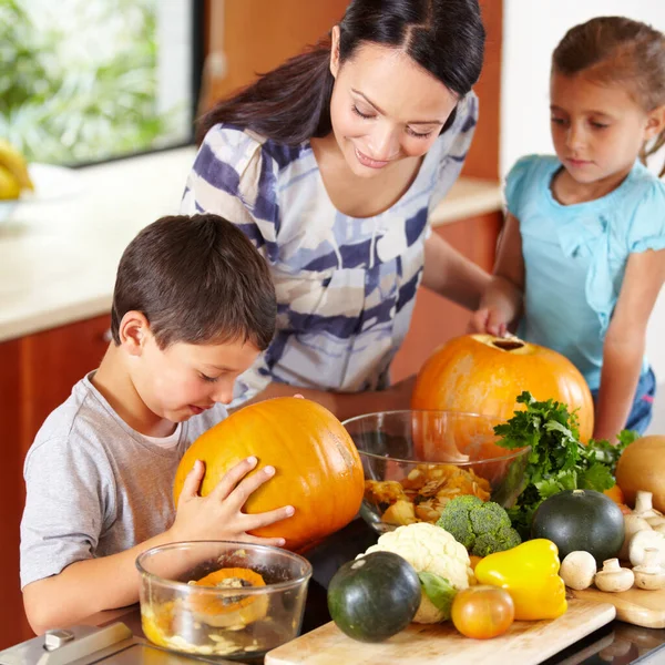 Credo sia pronto. Colpo di madre che aiuta i suoi figli a scolpire le zucche per Halloween. — Foto Stock
