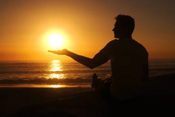 Tengo la luz del mundo en mis manos. La silueta de un hombre sosteniendo la palma de su mano para que el sol descanse en ella. —  Fotos de Stock