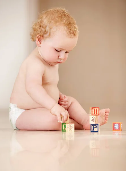 通过互动学习。可爱的小宝宝坐在地上玩字母表. — 图库照片