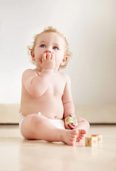 Filled with curiousity and wonder. Cute baby boy looking up curiously while sitting on the floor. — Stock Photo, Image
