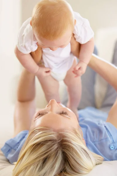 Mam en dochter hebben een band. Een schattig meisje dat door haar moeder de lucht in wordt getild. — Stockfoto