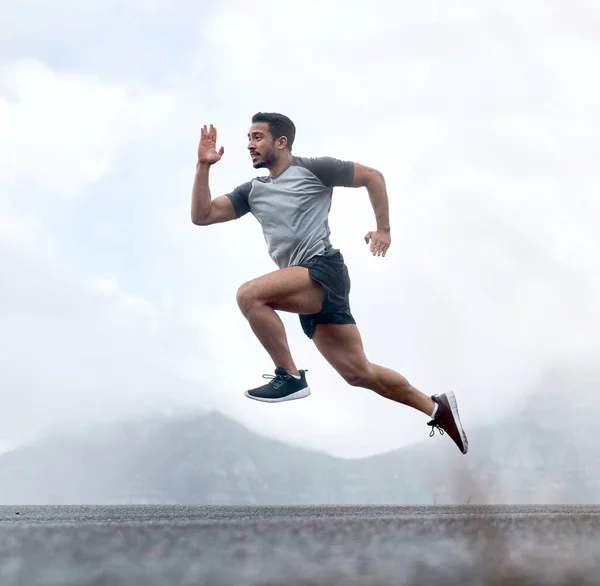 De lichamen die tot alles in staat zijn als de geest sterk is. Full length shot van een knappe jongeman springen tijdens een training buiten. — Stockfoto