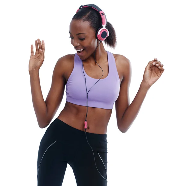 Moving to the beat. A woman in sportswear happily listening to music with her headphones. — Stock Photo, Image