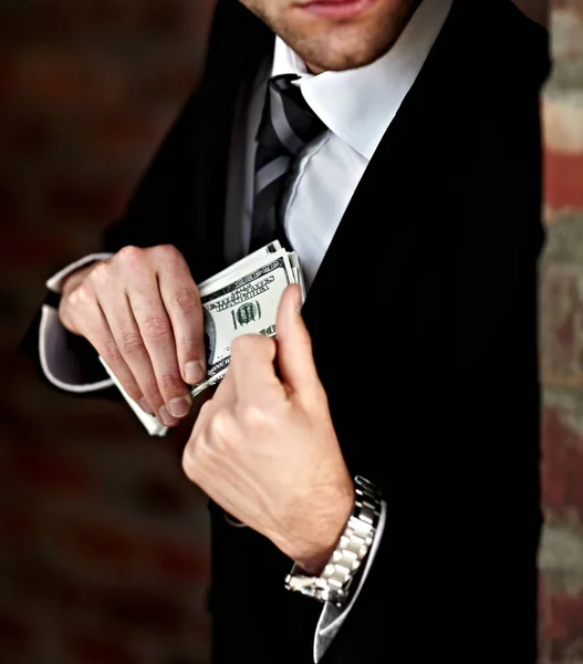 Han fick sin muta. Beskuren bild av en man som stoppar in en bunt pengar i sin jacka. — Stockfoto