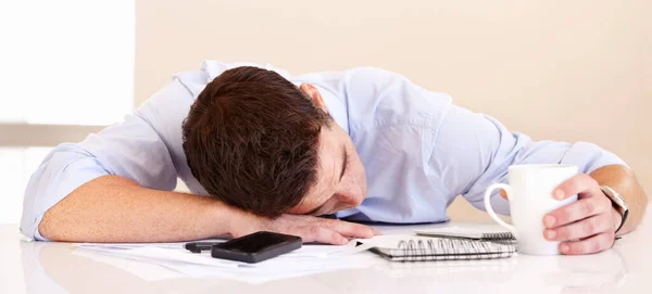 No le queda energía. Exhausto hombre de negocios acostado en su escritorio junto con su teléfono móvil. — Foto de Stock