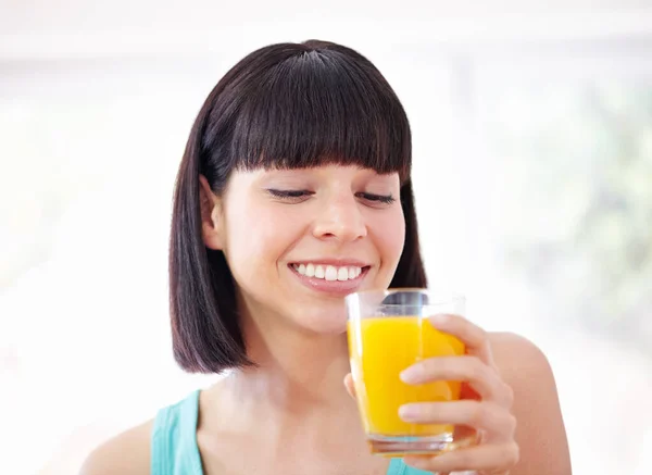 Cieszymy się kieliszkiem soczystego dobroci. Młoda kobieta pijąca sok pomarańczowy. — Zdjęcie stockowe