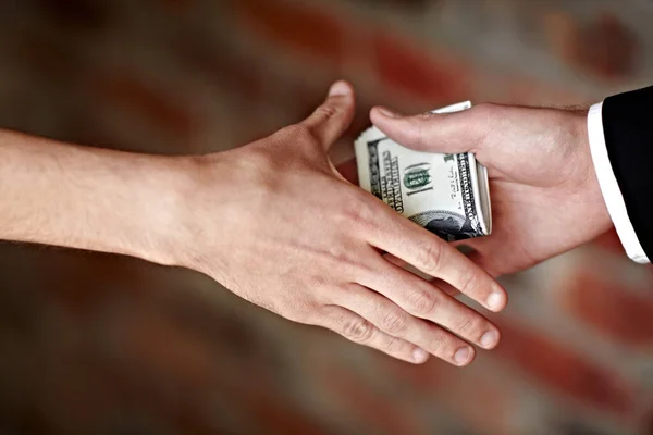 Eine Bestechung. Abgeschnittene Hände erhalten eine illegale Belohnung. — Stockfoto