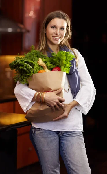 Büszke az egészséges ételekre. Vonzó nő kezében egy papírzacskó friss zöldség. — Stock Fotó