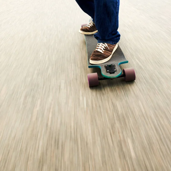 Bruslení vyžaduje zručnost a preciznost. Vystřižený záběr muže na skateboardu ve vysoké rychlosti. — Stock fotografie