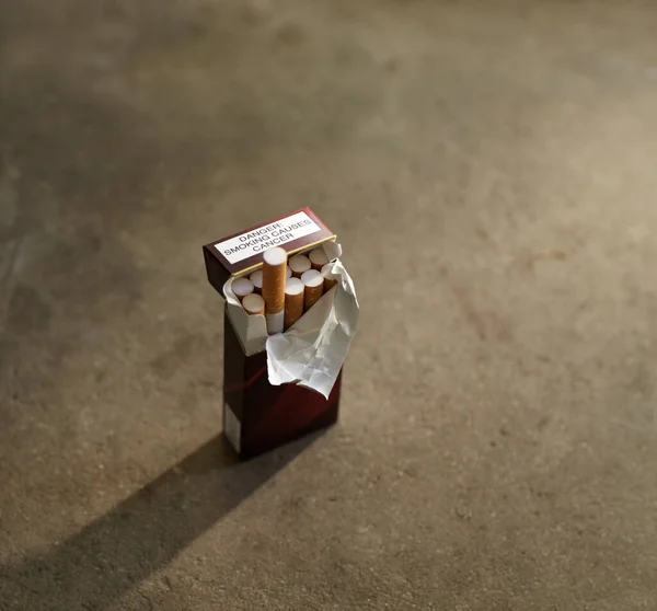 La tentación del mal. Primer plano de una caja abierta de cigarrillos, con uno saliendo de la caja. — Foto de Stock