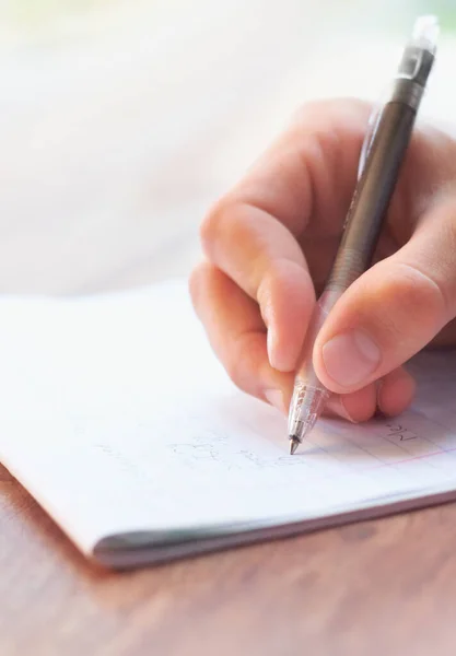 A pôr os pensamentos dele no papel. Tiro recortado de um homem de negócios escrevendo em um bloco de notas. Imagem De Stock