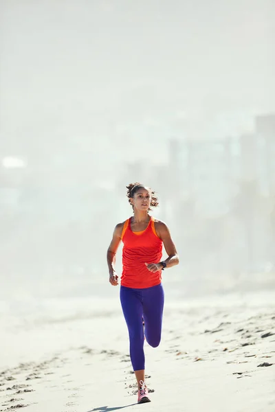 Υπάρχει κάτι μαγικό στο τρέξιμο. Πυροβολήθηκε μια αθλητική νεαρή γυναίκα στην παραλία για το πρωινό της τρέξιμο.. — Φωτογραφία Αρχείου