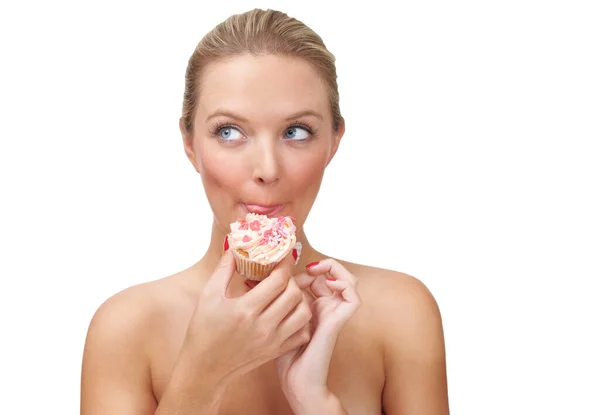 Rubare un po 'di dolcezza. Una donna bionda dall'aspetto cattivo che mangia un cupcake. — Foto Stock