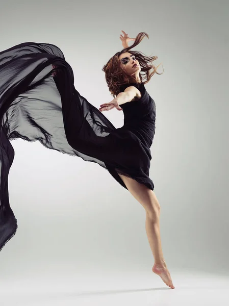 Sei fließend du selbst. Studioaufnahme einer schönen jungen Frau in einem fließenden Kleid vor grauem Hintergrund. — Stockfoto