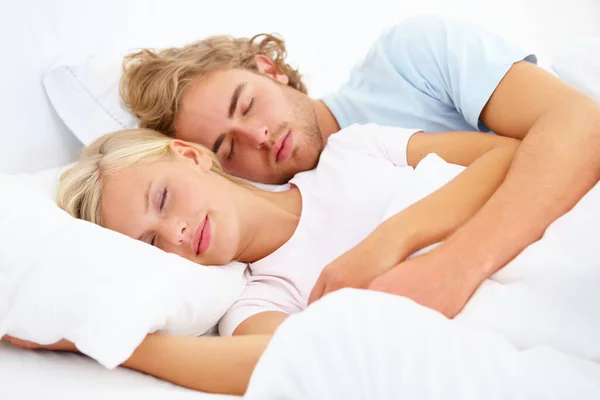 Durmiendo en sus brazos. Una joven pareja dormida en la cama juntos. —  Fotos de Stock