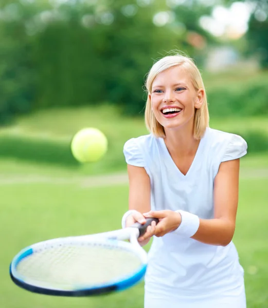 Sólo por diversión. Una joven jugadora de tenis rebotando la pelota en su raqueta por diversión. — Foto de Stock