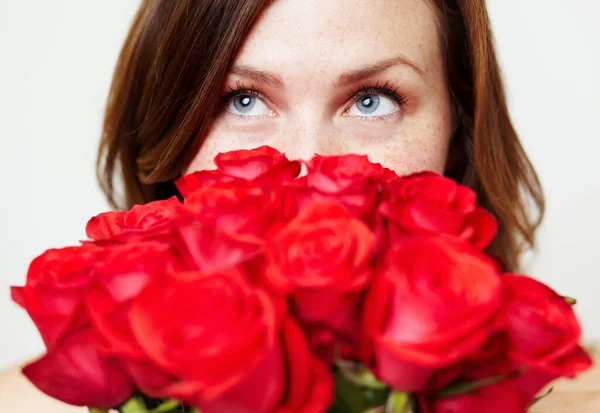 Estou a pensar naquela pessoa especial. Uma jovem atraente olhando sobre um buquê de rosas. — Fotografia de Stock