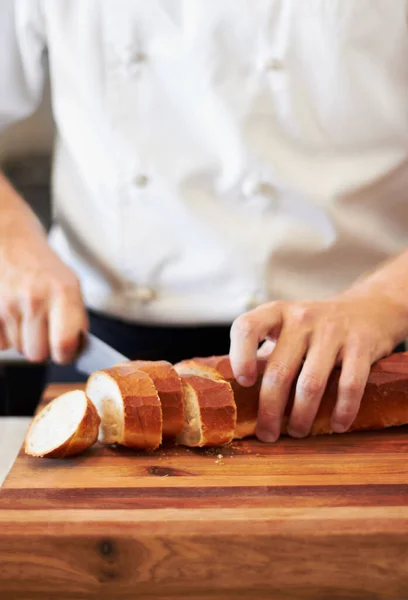 Презентация это все. Пекарь режет французский хлеб. — стоковое фото