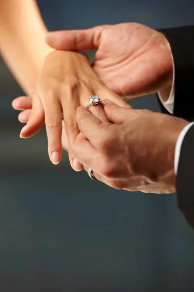 Ein Gelöbnis ablegen. Ausgeschnittene Ansicht eines Bräutigams, der seinen Bräuten einen Ring an den Finger legt. — Stockfoto