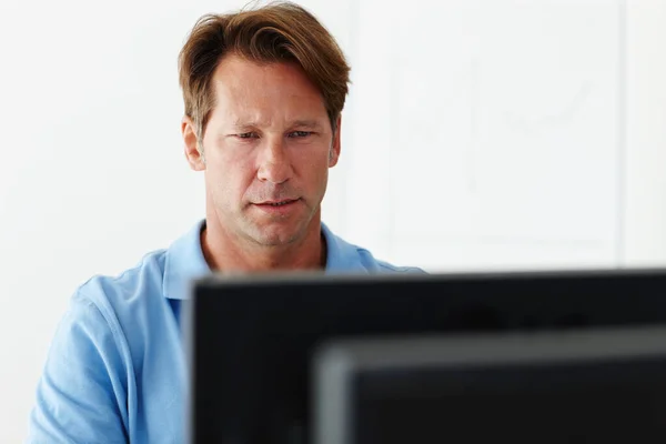 Una pantalla mantiene toda su atención. Tiro de un hombre maduro concentrándose en la pantalla de su ordenador. — Foto de Stock