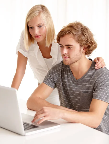 Sto pensando a una password. Una giovane coppia che usa un computer portatile per navigare in rete. — Foto Stock