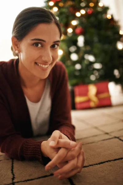 祝你有一个圣洁快乐的圣诞节。一个年轻貌美的女人身后有一棵圣诞树的画像. — 图库照片