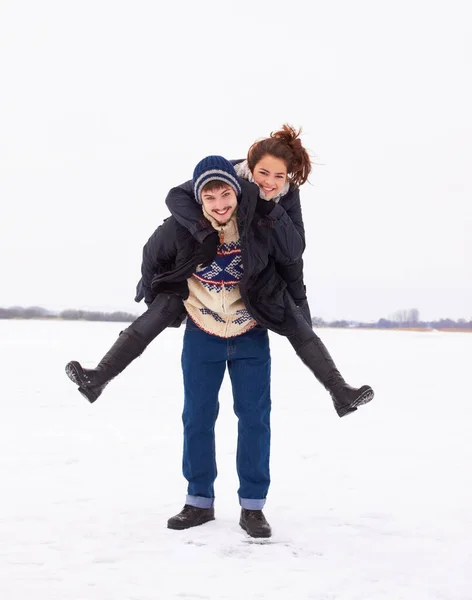 Ich liebe dieses Wetter. Ein nettes junges Paar spielt auf dem Eis eines zugefrorenen natürlichen Sees. — Stockfoto