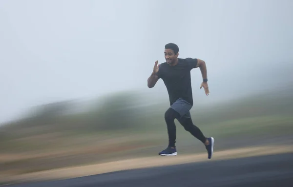 Ik versnel het tempo. Een foto van een sportieve jongeman die buiten rent.. — Stockfoto