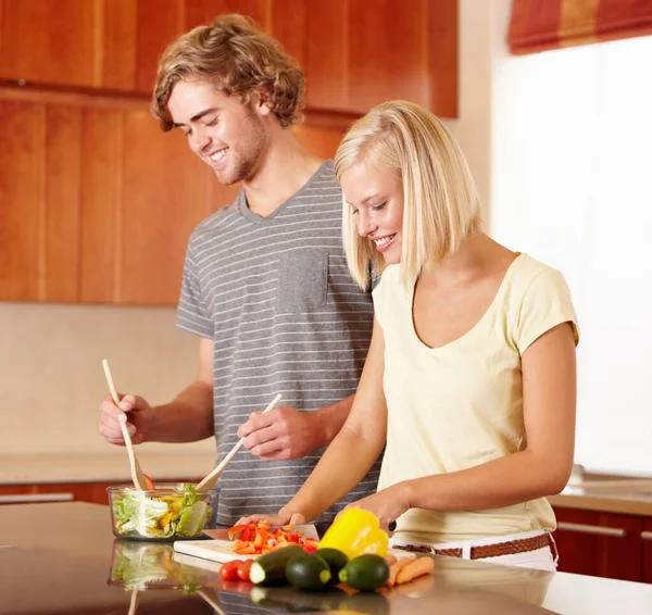 Cozinhar juntos. Um jovem casal fazendo o jantar na cozinha. — Fotografia de Stock