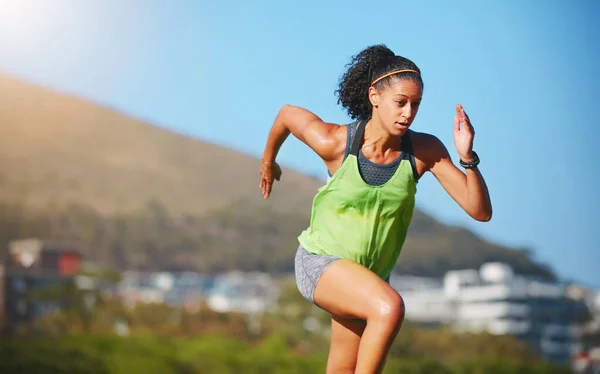 Aproximando-se dos seus objetivos de fitness. Tiro de uma jovem desportiva que se exercita ao ar livre. — Fotografia de Stock