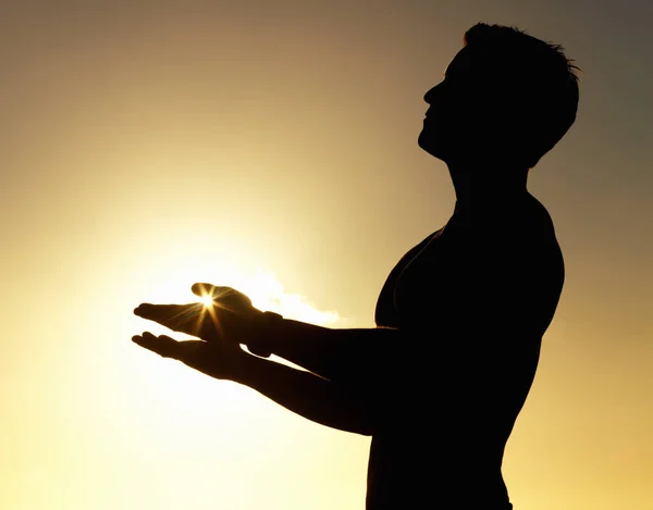 Güneşi selamlayın. Elleri havada sakince duran bir adamın silüeti.. — Stok fotoğraf