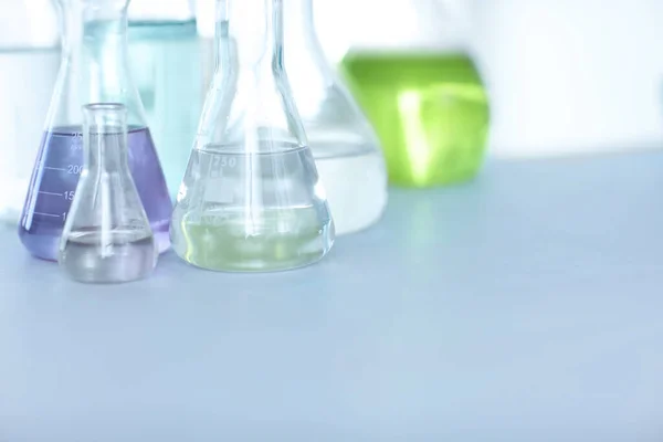 Χημικές ενώσεις. Φιαλίδια γεμάτα με πολύχρωμο υγρό σε ένα τραπέζι σε ένα εργαστήριο. — Φωτογραφία Αρχείου