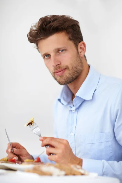 Ik geniet van goed bereide gerechten. Knappe jongeman die geniet van een maaltijd in een goed restaurant. — Stockfoto