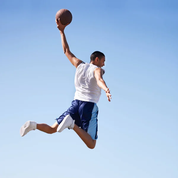 De zwaartekracht trotseren. Een jonge atleet die een vliegende sprong maakt. — Stockfoto