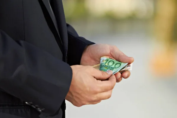 Gewinne machen. Zugeschnittenes Bild eines Geschäftsmannes beim Zählen von Bargeld. — Stockfoto