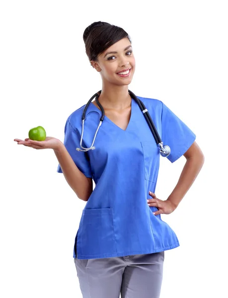 Wiesz, co mówią o jabłku dziennie. Studyjne ujęcie młodego medyka trzymającego jabłko na białym. — Zdjęcie stockowe