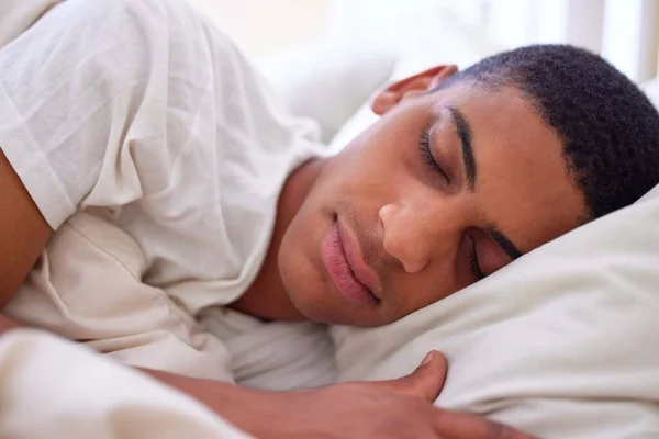 私の美しさの睡眠を取得。自宅で朝の早い時間にベッドで寝ているハンサムな若い男の作物のショット. — ストック写真