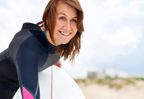 Ze kan niet wachten om het water te raken. Een jonge vrouwelijke surfer maakt zich klaar om naar buiten te gaan en te genieten van de golven op een hete zomerdag. — Stockfoto