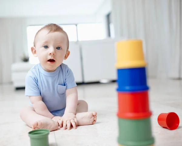 Los bloques de construcción para una mente brillante. Un niño juguetón sentado en el piso de la sala. —  Fotos de Stock