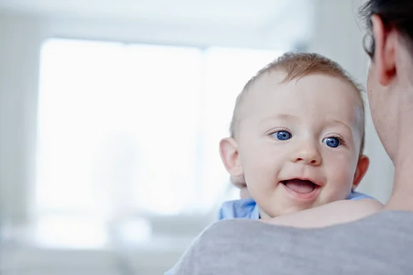 Blij om in zijn moeders armen te zijn. Close-up van een gelukkige baby jongen wordt vastgehouden door zijn moeder. — Stockfoto