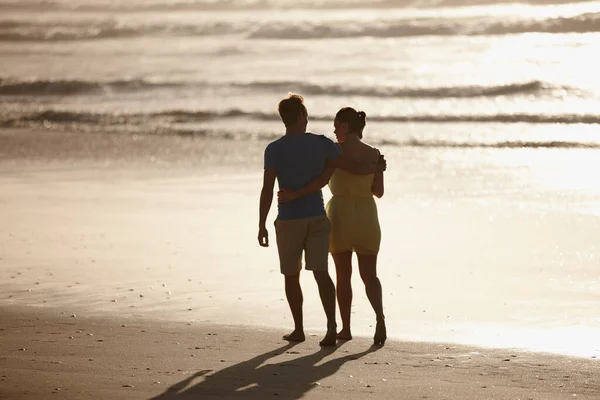 Рано утром гуляю по пляжу. Снимок любящей пары, гуляющей по пляжу. — стоковое фото