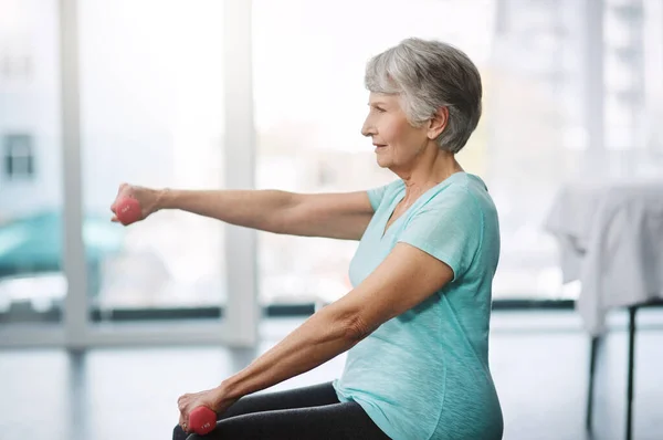 Pracuje nad utrzymaniem zdrowia. Ujęcie zdrowej starszej kobiety ćwiczącej z hantlami. — Zdjęcie stockowe