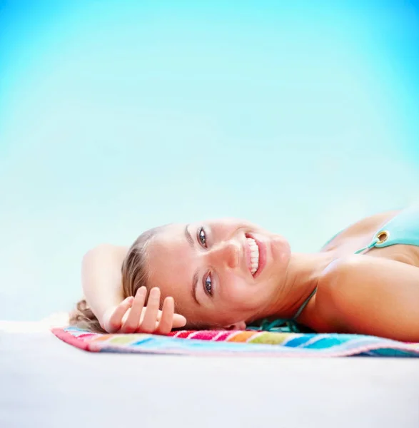Maviye karşı bikinili mutlu bir kadın. Bikinili gülümseyen genç bayan mavi arka planda güneşlenmek için dinleniyor.. — Stok fotoğraf