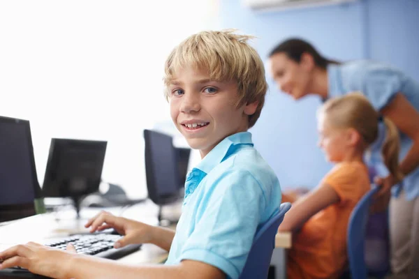 Je suis bon en informatique. Portrait d'un écolier mignon en classe d'informatique. — Photo