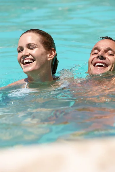 Virkistävä kesärentoutuminen. Pari uimassa yhdessä uima-altaassa.. — kuvapankkivalokuva
