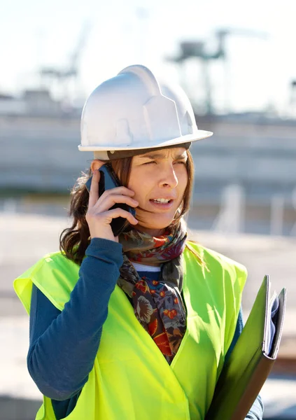Resolver las necesidades de construcción. Una trabajadora de la construcción hablando por teléfono. — Foto de Stock