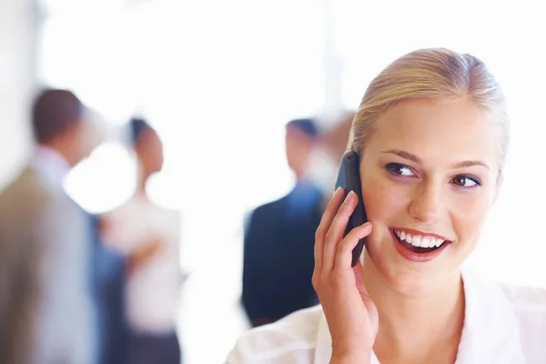 Linda mujer de negocios en llamada telefónica. Primer plano de la ejecutiva linda en la llamada telefónica con el equipo de negocios en segundo plano. — Foto de Stock