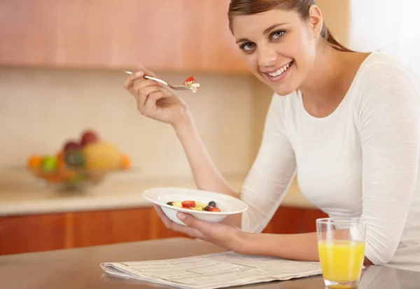 健康的な朝食をお楽しみください。魅力的な若い女性の肖像画彼女の朝食を食べるキッチンで. — ストック写真